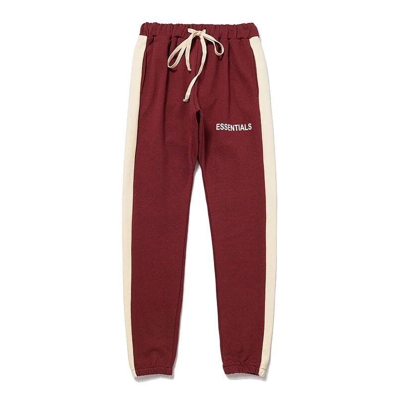 Red and cream sweatpants with "ESSENTIALS" print, casual K-pop style apparel, suitable for fans and everyday wear.
