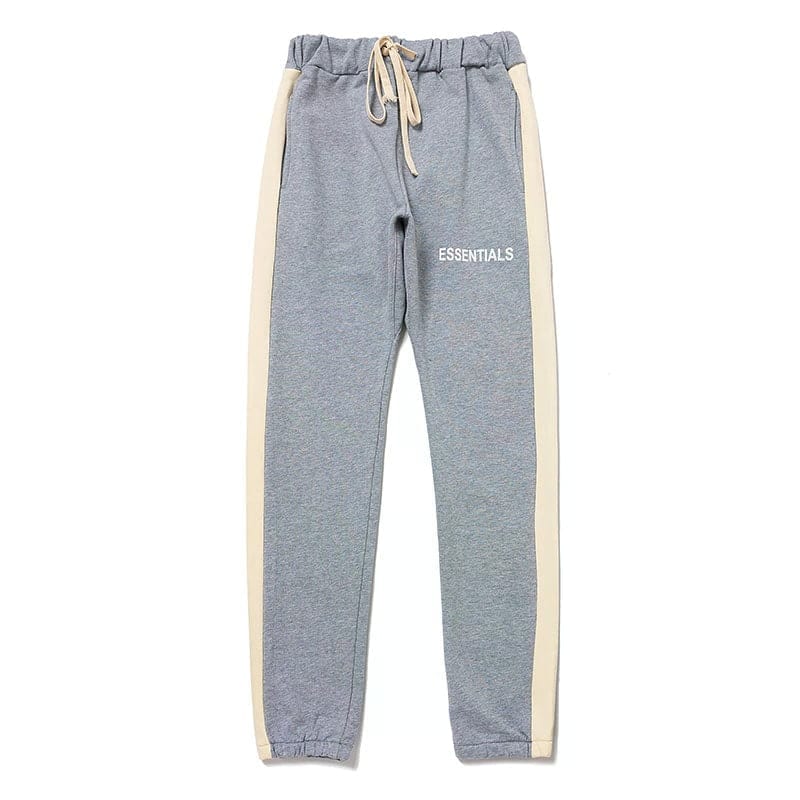 Comfy gray jogger sweatpants with beige side stripes and "ESSENTIALS" text, perfect for casual wear or working out.