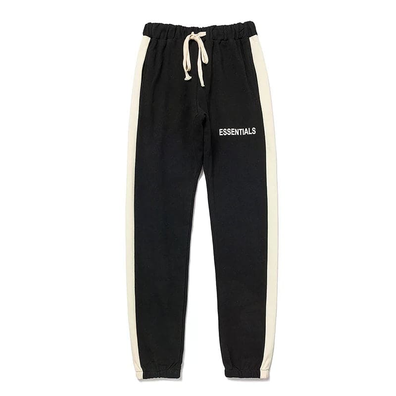 Black and white jogger pants with "ESSENTIALS" text, perfect for K-pop merchandise fans.