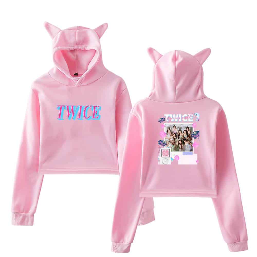 TWICE pink hoodie with cat ears, featuring group photo and fan art on the back, perfect for K-pop merch fans.
